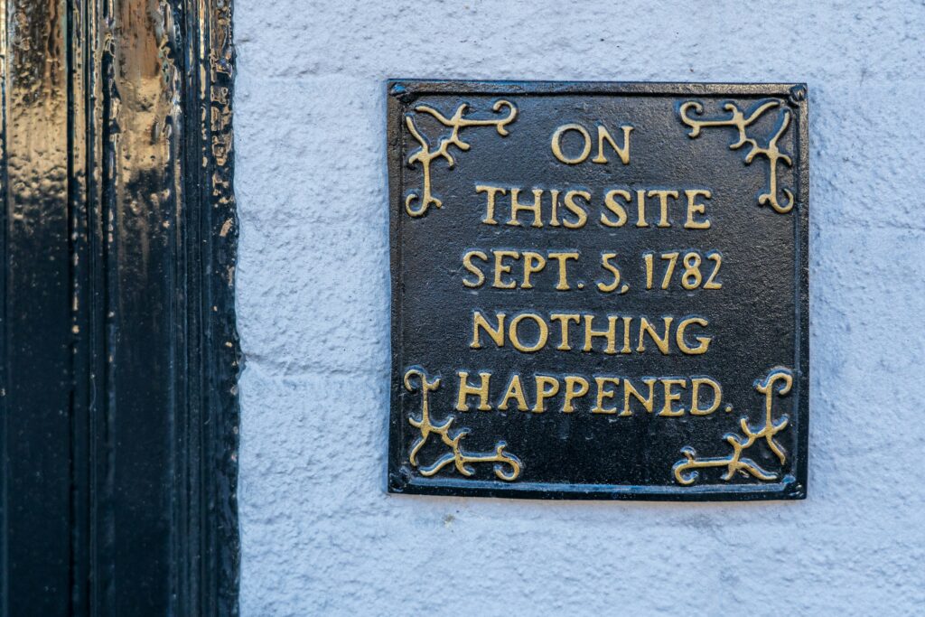 Plakkaat aan muur met engelse tekst: "on this site september 5, 1782 nothing happened"